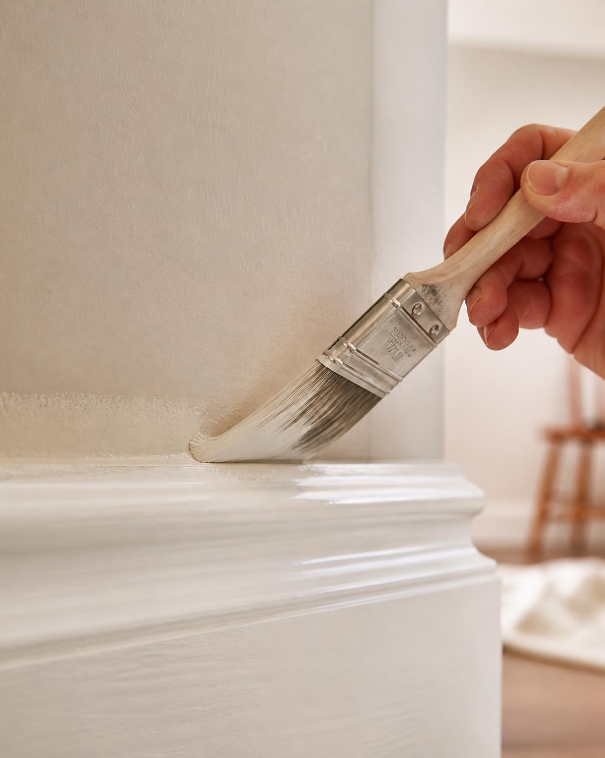 Painter cutting in a crisp paint line along interior trim